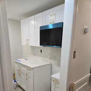 white kitchen cabinets with microwave above counters